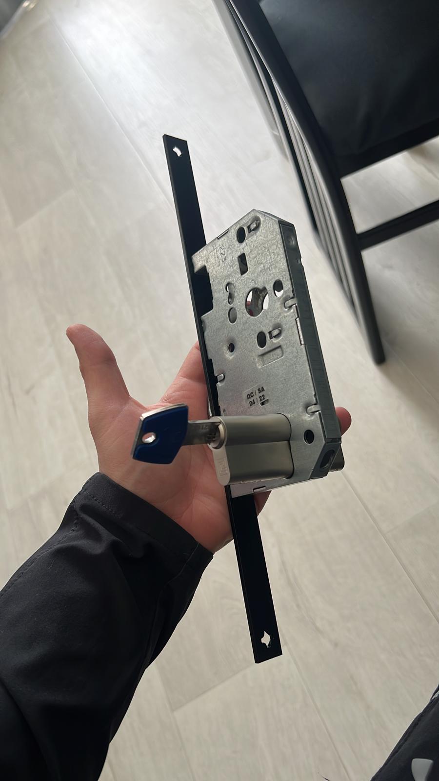 Changement de serrure une serrure monopoint avec un cylindre dans une main.